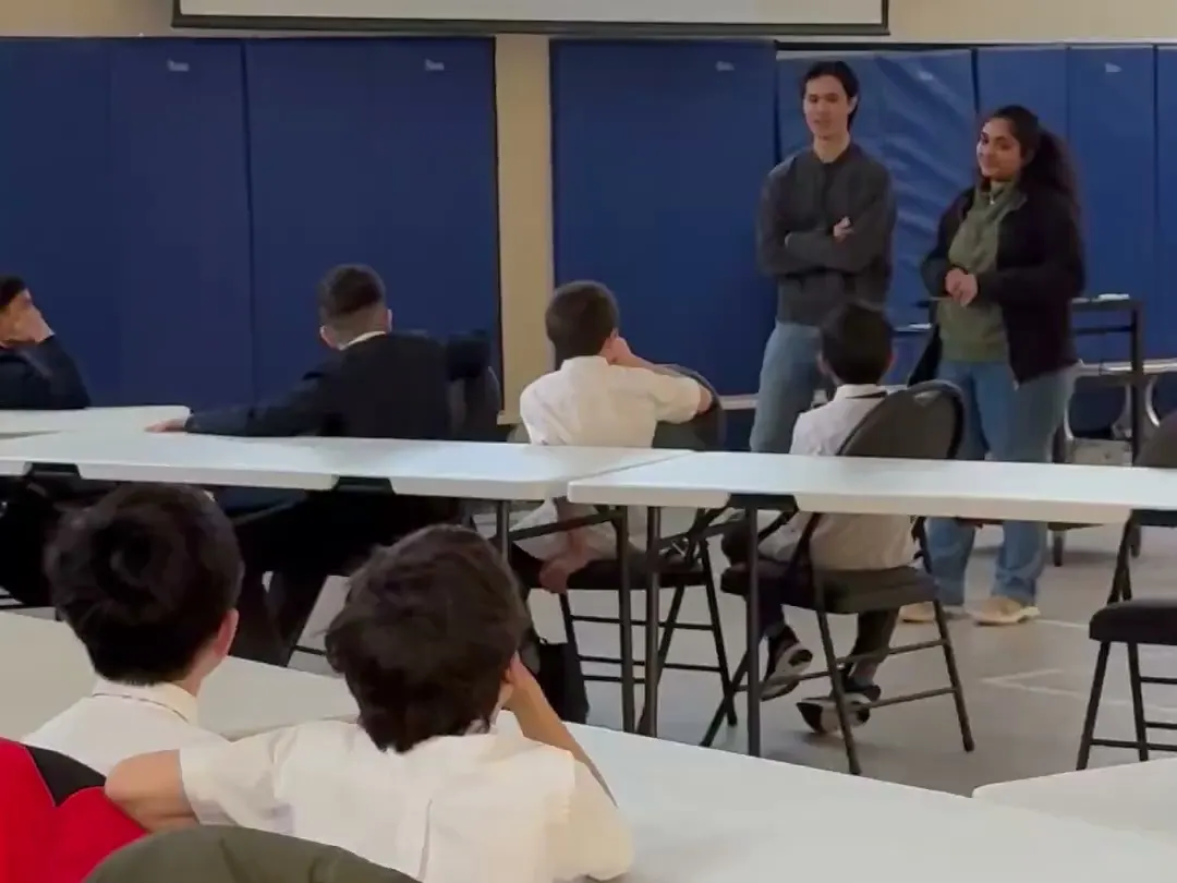 Cyber Square instructors lead a session with older students in a school gym
